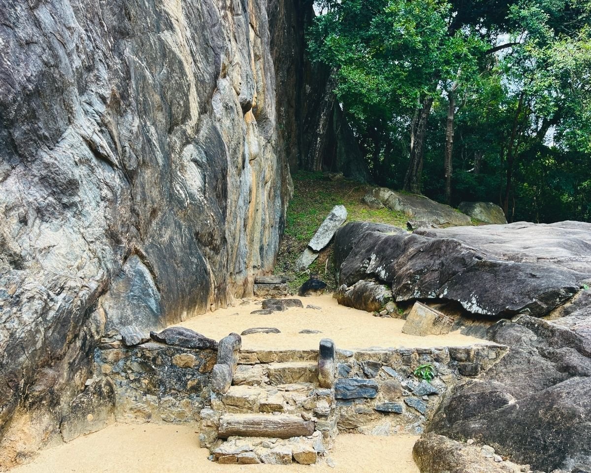 Stone steps and courtyard beneath the Buduruwagala cliff face