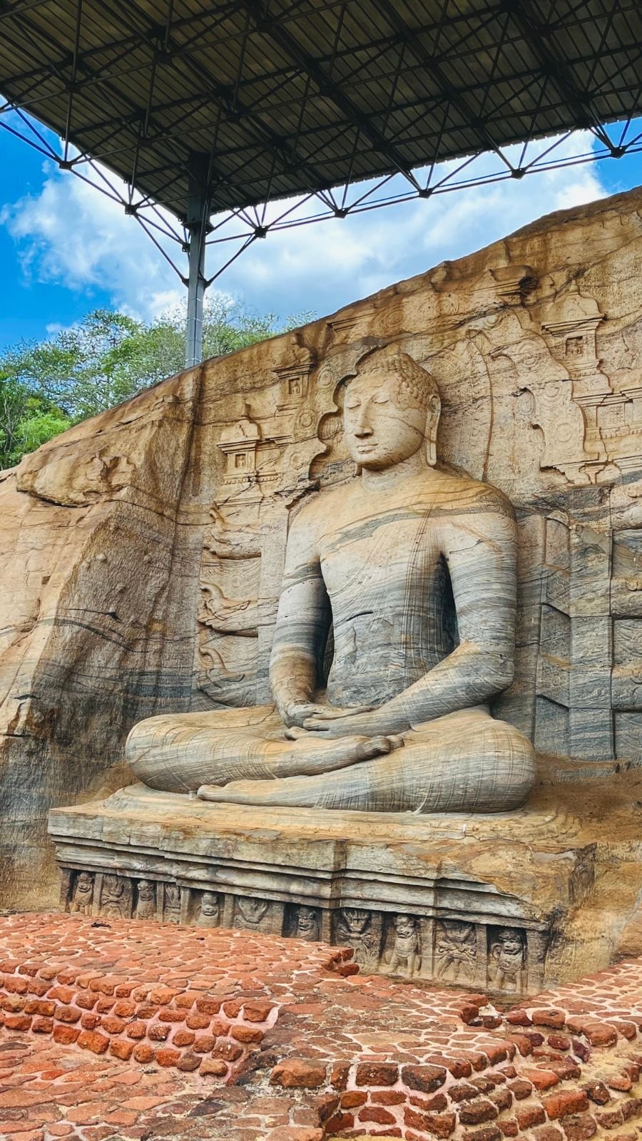 Gal Vihara, also known as Uttararama, in Polonnaruwa, Sri Lanka, showing the seated Buddha statue in Dhyana Mudra carved from granite with detailed shrine reliefs behind