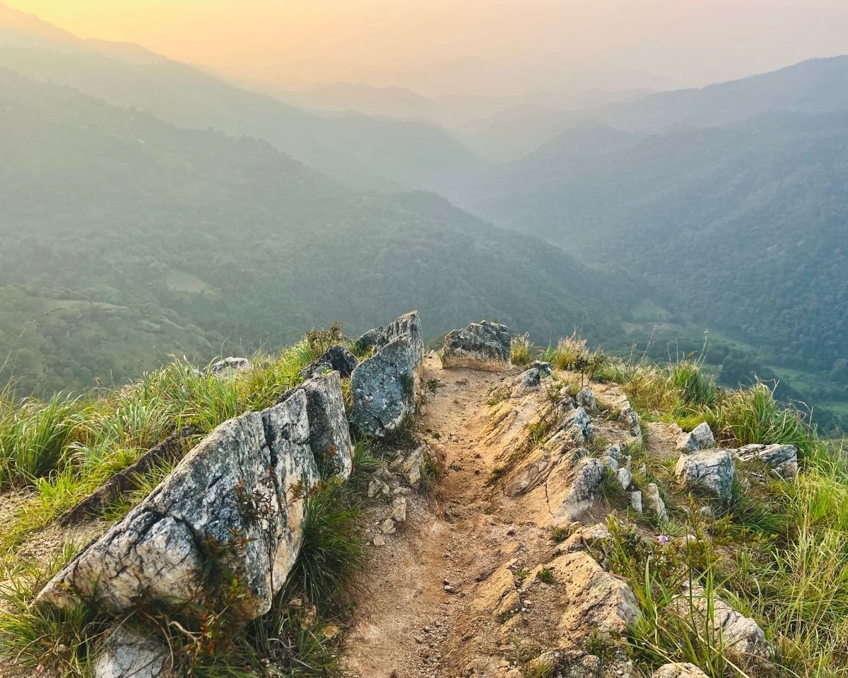 Narrow ridgeline trail overlooking misty valleys
