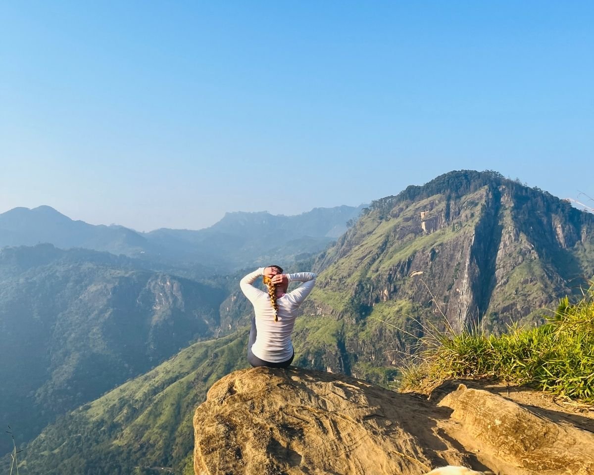 Traveler sitting on a rocky ledge above the valley