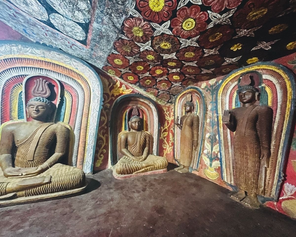 Buddha statues surrounded by ornate temple murals