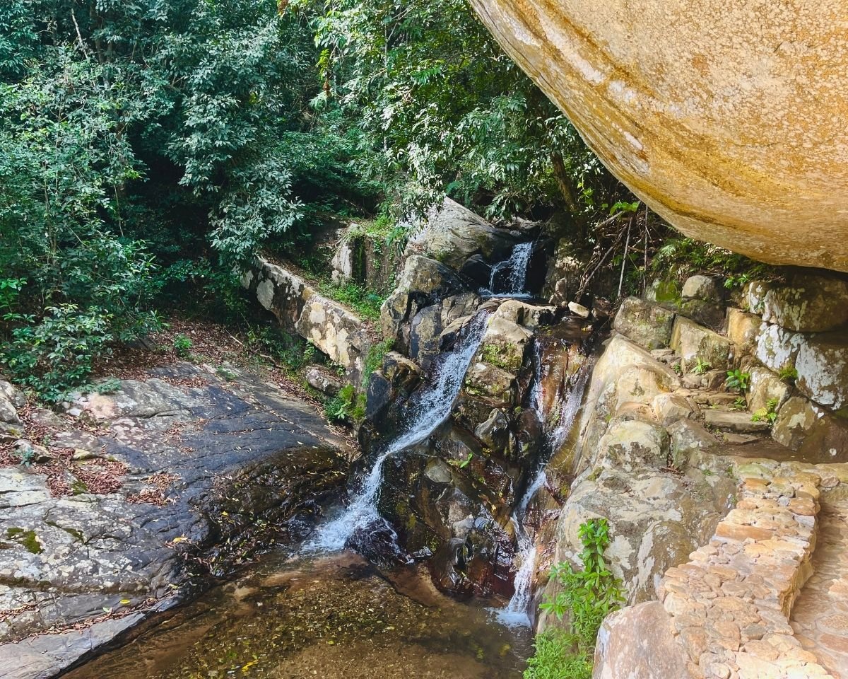 Small waterfall flowing beside the temple path