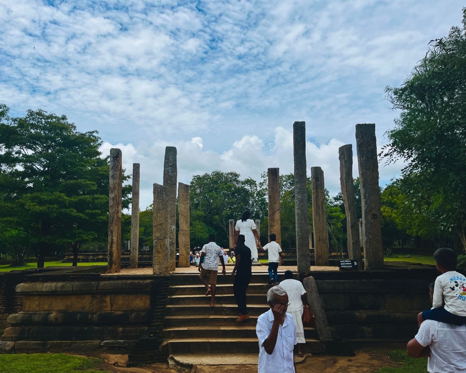Entrance pavilion to Rathna Prasadaya Chapter House at Abhayagiri, Anuradhapura, showing 10th-century raised stone platform with remaining granite pillars, the plain entrance beyond the ornate guardstone and dragon balustrade staircase