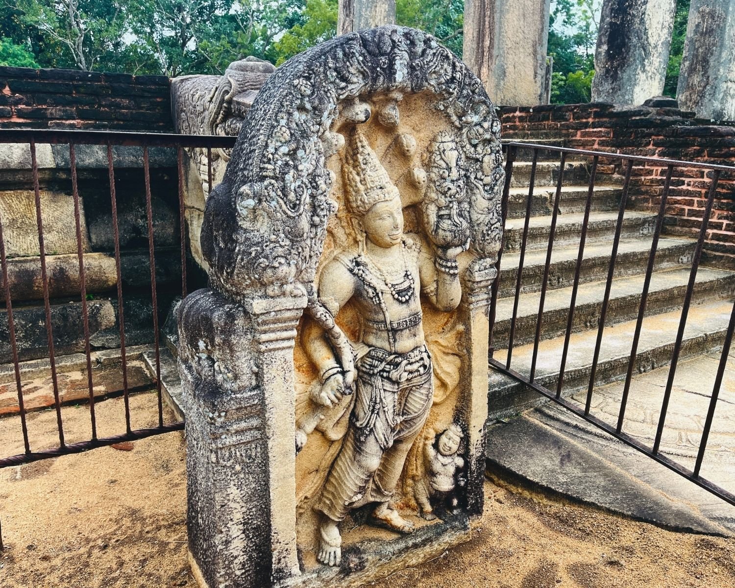 Rathna Prasadaya guardstone muragala at Abhayagiri, considered the most beautiful and detailed guardstone in Sri Lanka, 7th–9th century carving of Nagaraja cobra king under seven-hooded serpent canopy, holding punkalasa pot and lotus, with dwarf attendant, beside Chapter House staircase