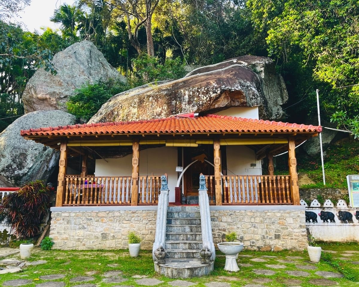 Temple building nestled beneath massive granite boulders