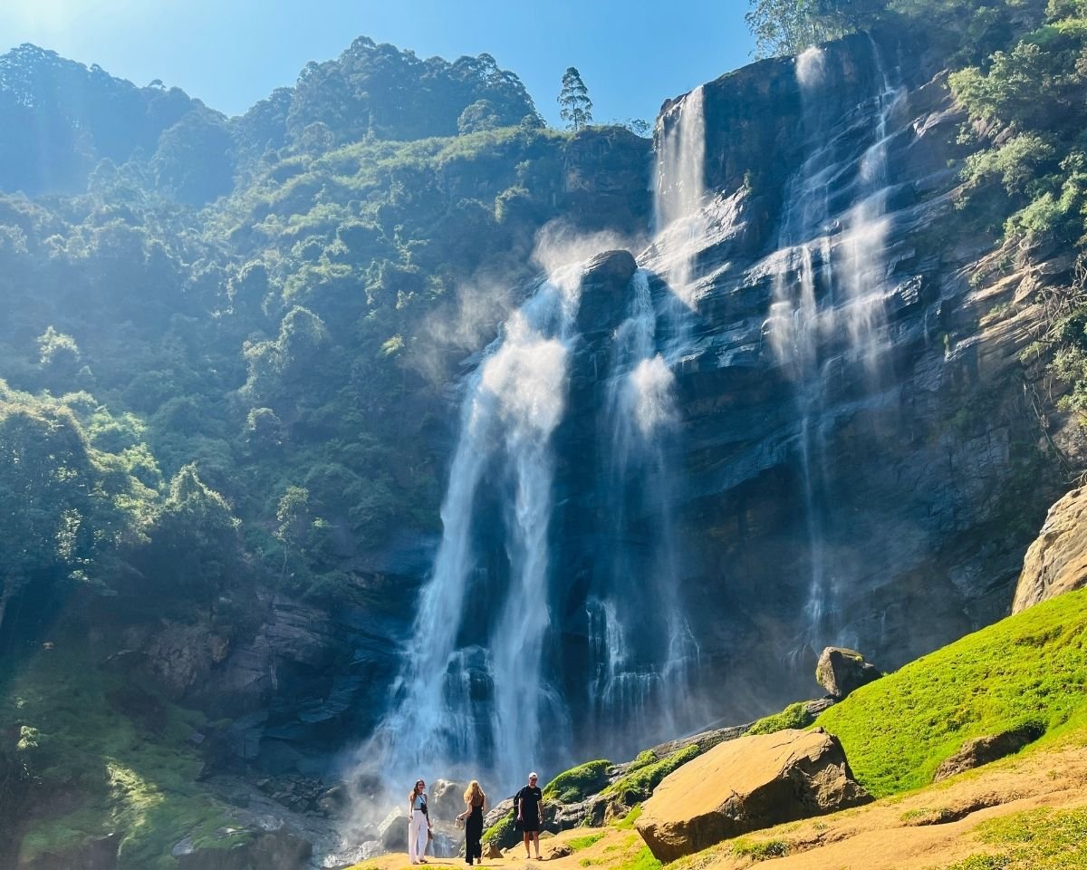 Bomburuella Waterfall powerful cascades and mist over wide cliff with sunlit mossy rocks at base near Nuwara Eliya Sri Lanka