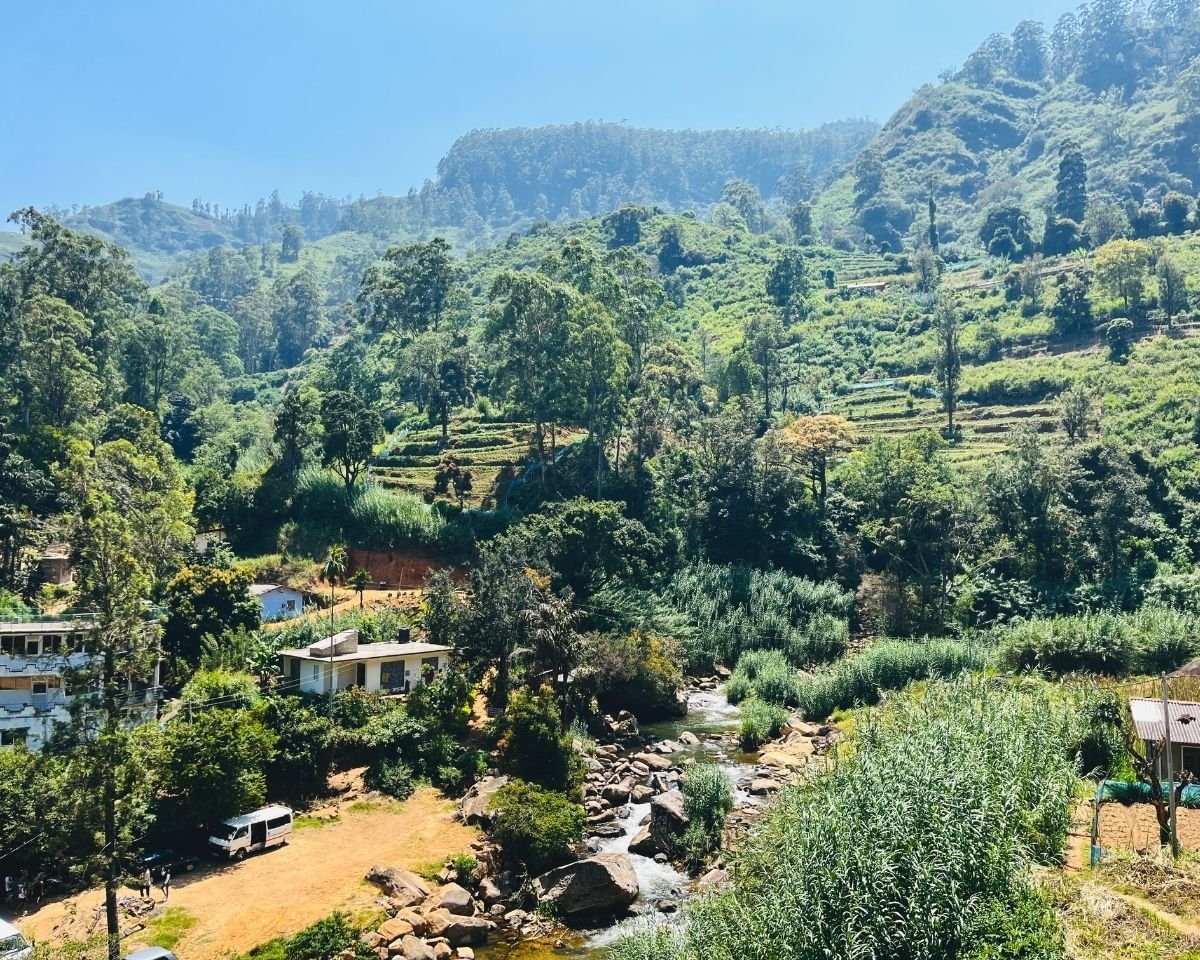 Stream cascade at Bomburuella trail start with main waterfall visible through forest in distance Nuwara Eliya Sri Lanka