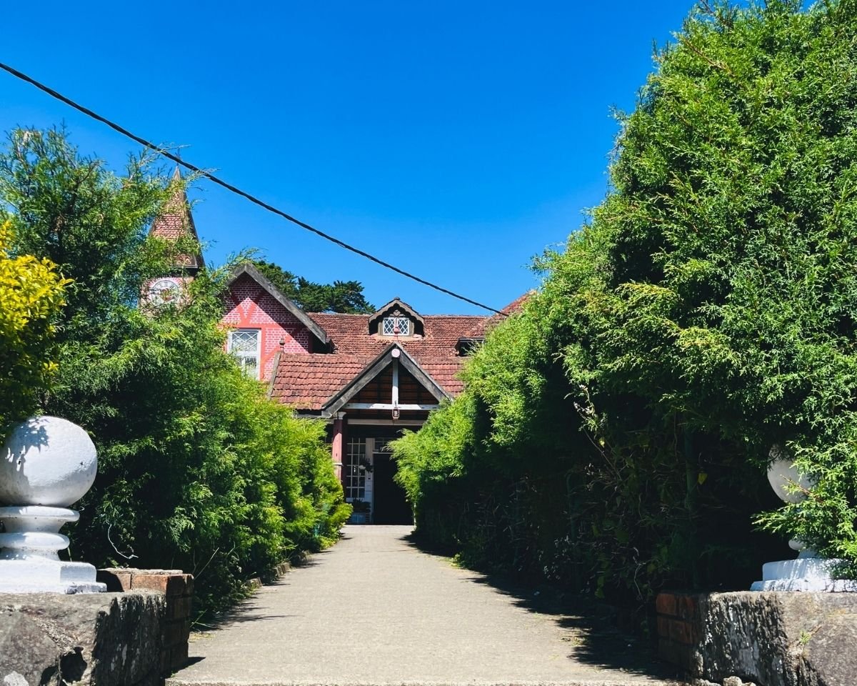 Nuwara Eliya Post Office red brick Tudor building with clock tower and hedged walkway under blue sky Sri Lanka