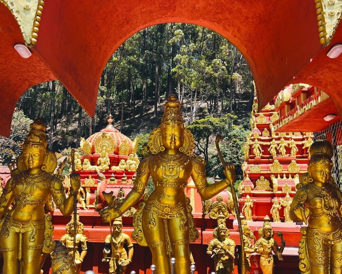 Gold statues of Lord Rama, Lakshmana and Sita at the Rama shrine in Seetha Amman Kovil Hindu temple, Nuwara Eliya, Sri Lanka with vimana and gopuram behind