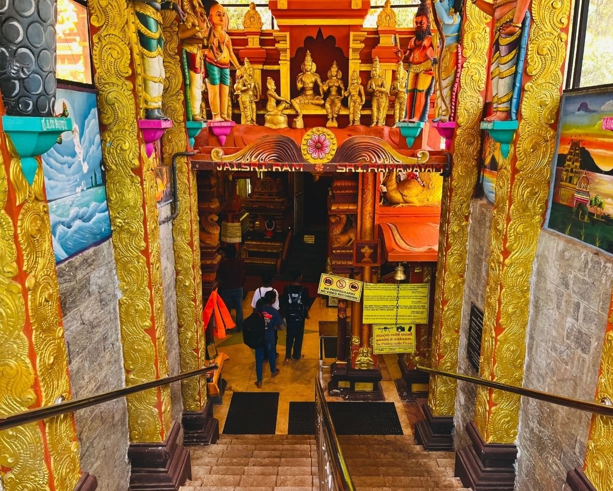 Entrance to the main sanctum at Seetha Amman Kovil Hindu temple in Nuwara Eliya, Sri Lanka with gold pillars, deity statues, and Jai Sri Ram sign above doorway