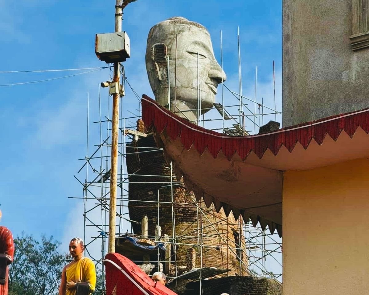 Unfinished concrete Buddha statue head with steel scaffolding by side of image house at Swarnagiri Maha Viharaya Single Tree Temple Nuwara Eliya Sri Lanka