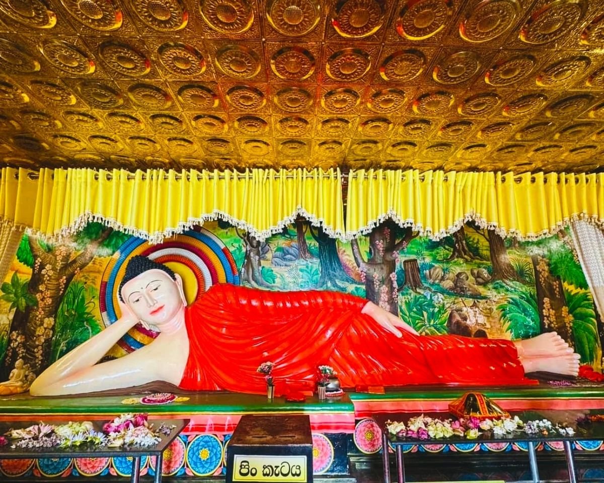 Reclining Buddha statue with gold embossed ceiling and forest mural inside image house at Swarnagiri Maha Viharaya Single Tree Temple Nuwara Eliya