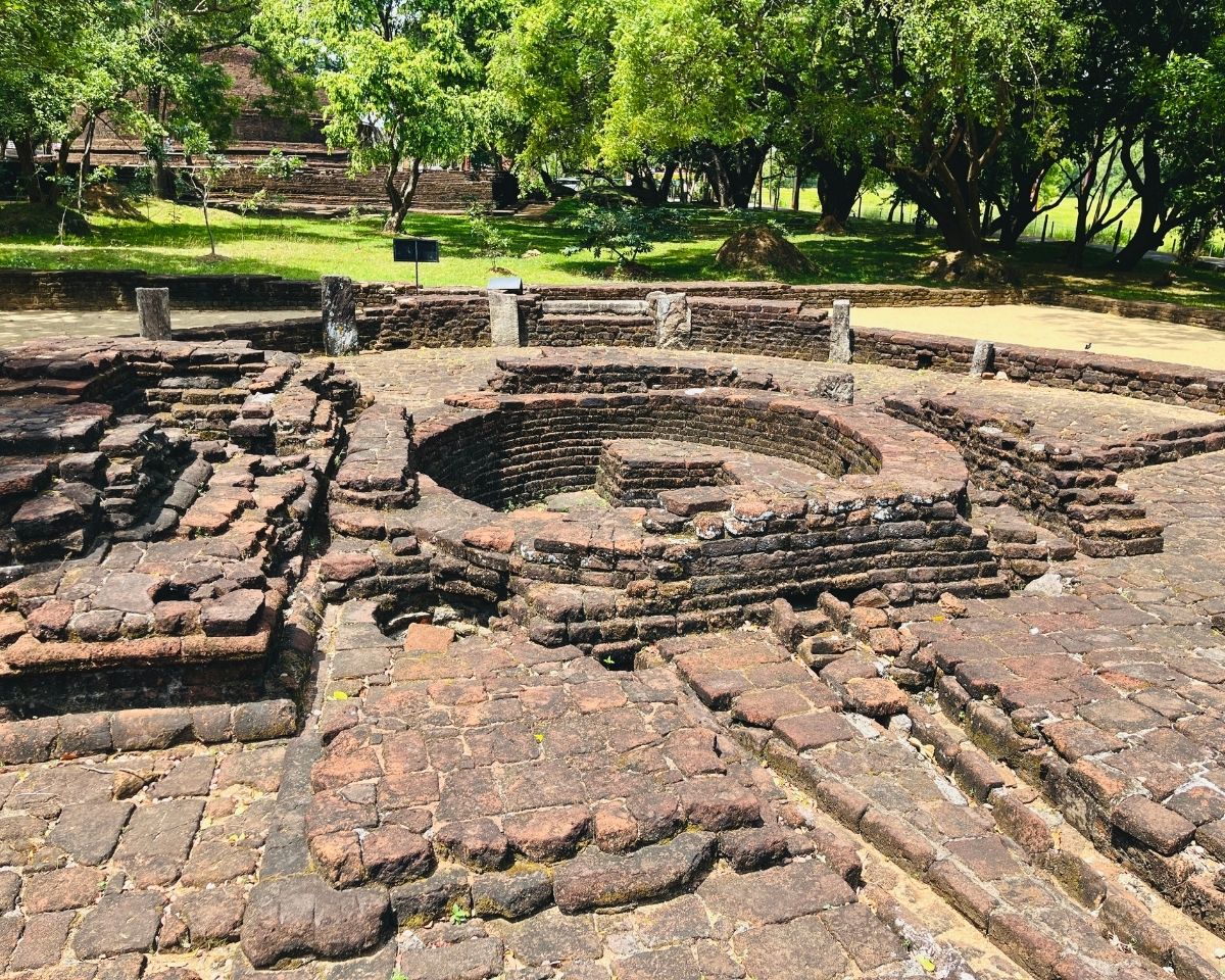 Close up detailed view of circular brick base structure of Bodhighraya Bodhi Tree Shrine with weathered red bricks and stone pillars at Dambulla Somawathiya Sri Lanka
